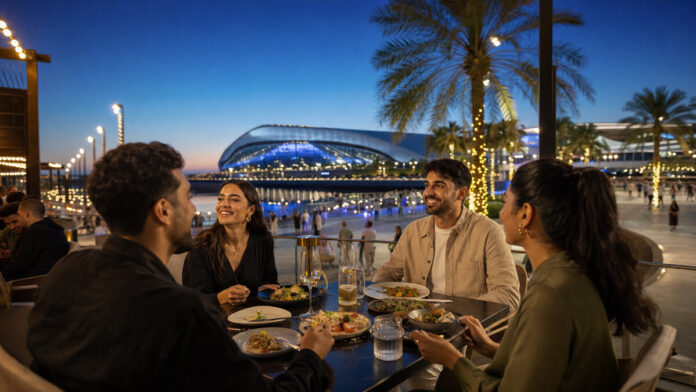 Friends dining on a Yas Bay waterfront terrace before an arena event
